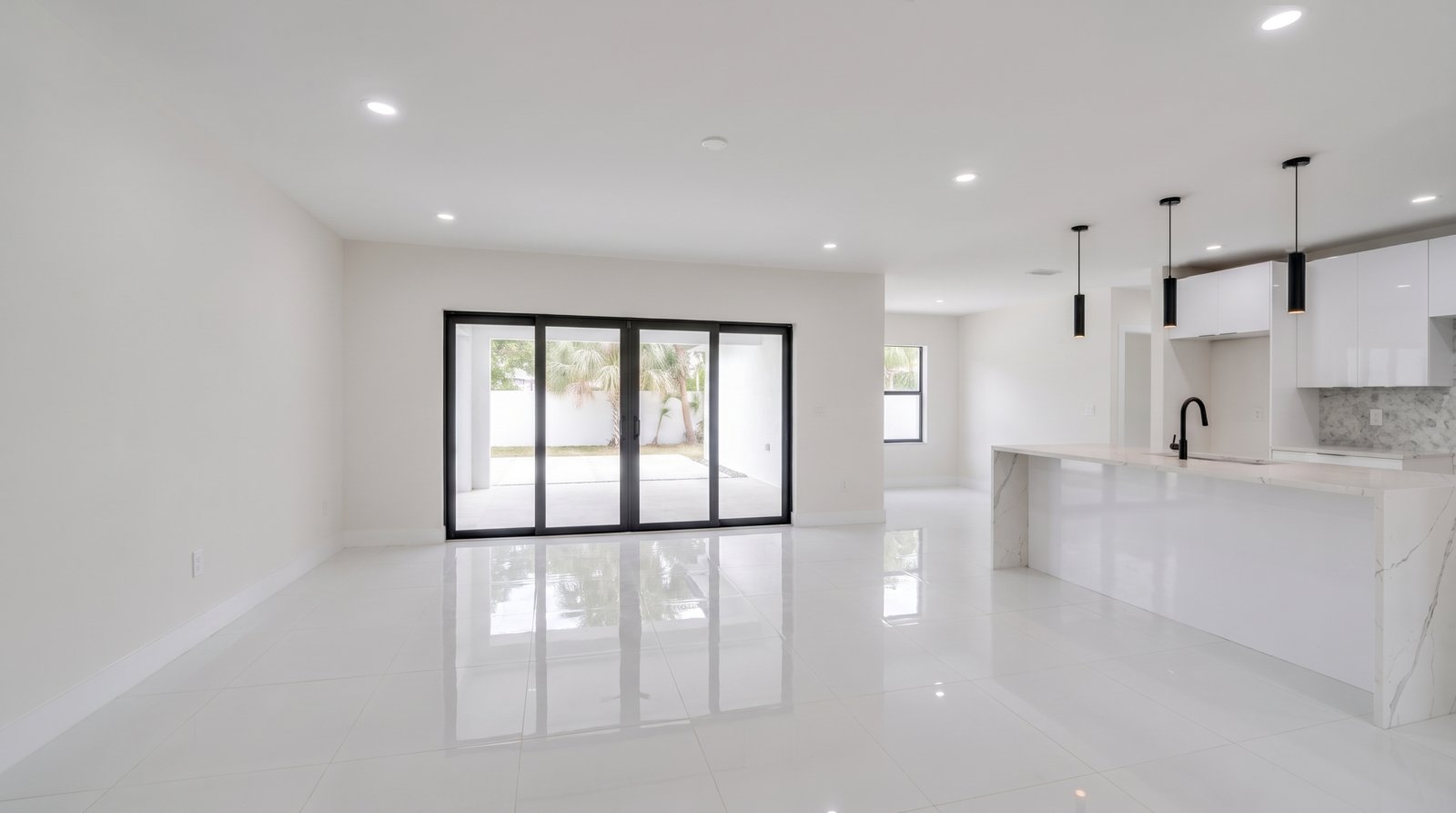 The same open living room and kitchen, empty and unstaged